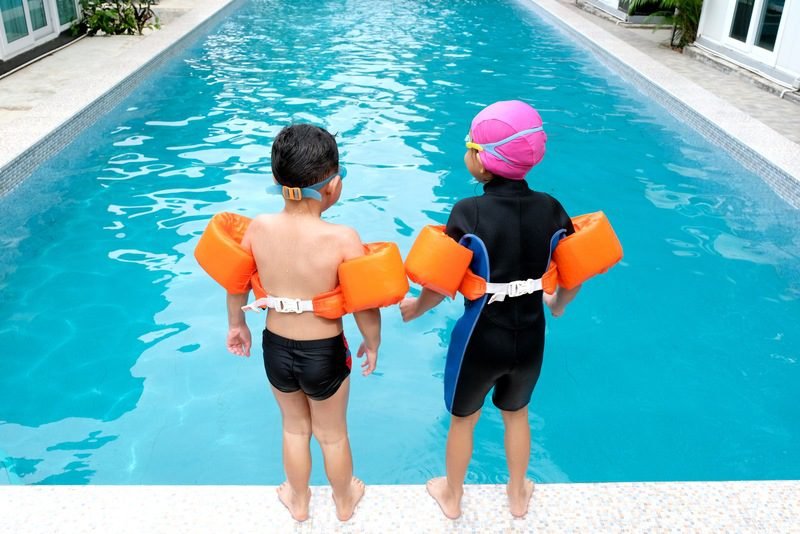 Swimming instructor teaching water safety skills to children in Canadian swimming program