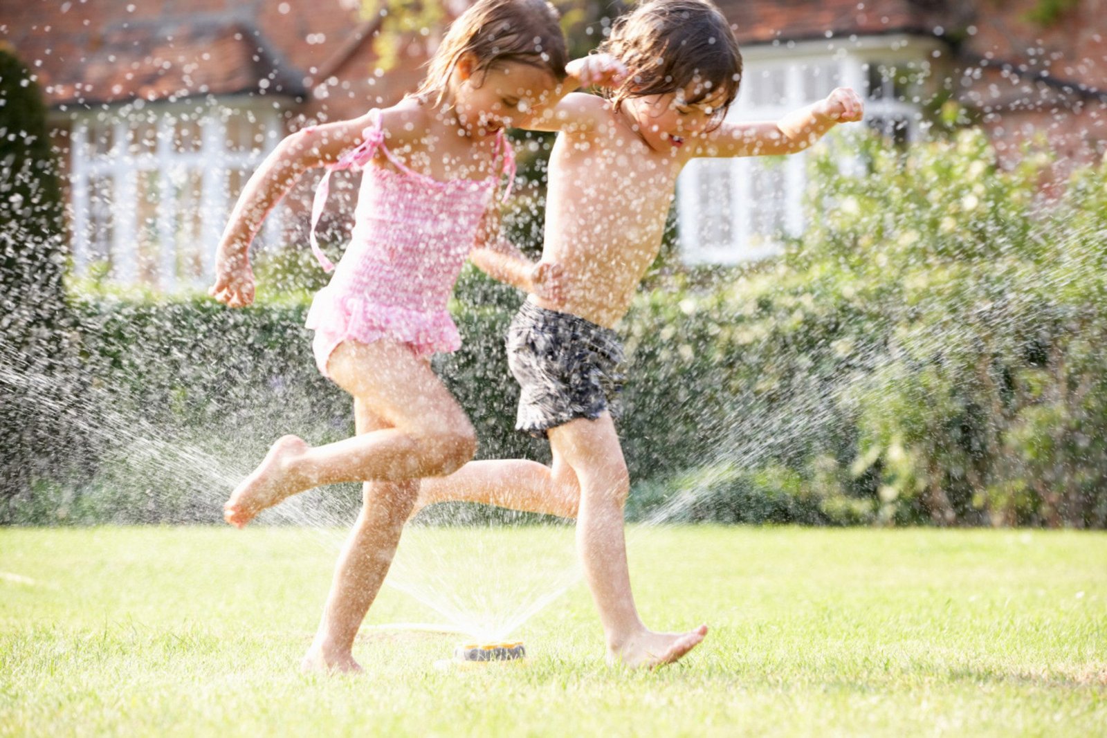 Parents applying sunscreen and safety gear for summer outdoor activities with children