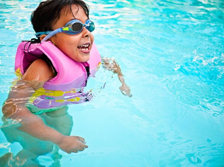 Swimming instructor teaching water safety skills to children in Canadian swimming program