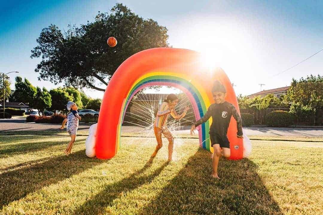Family enjoying outdoor summer fun activities at beach with children building sandcastles