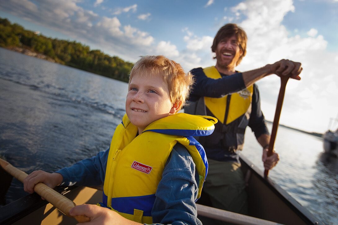 Canadian family enjoying outdoor summer fun camping in nature with tent and campfire
