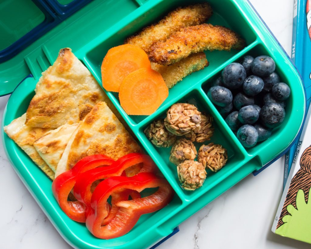 Bento box style lunch with compartments filled with kid-friendly foods for picky eaters