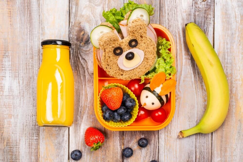 Fun lunch box with bear-shaped sandwich and creative food arrangements for kids