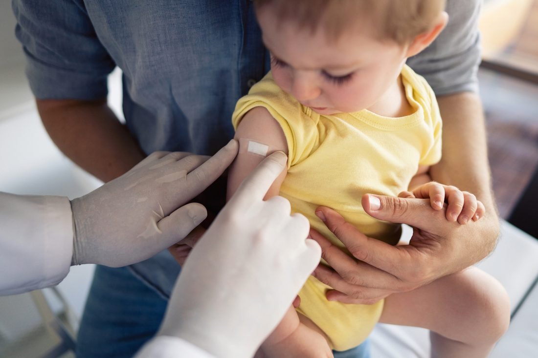 Healthcare professional administering infant flu vaccine shot to Canadian baby