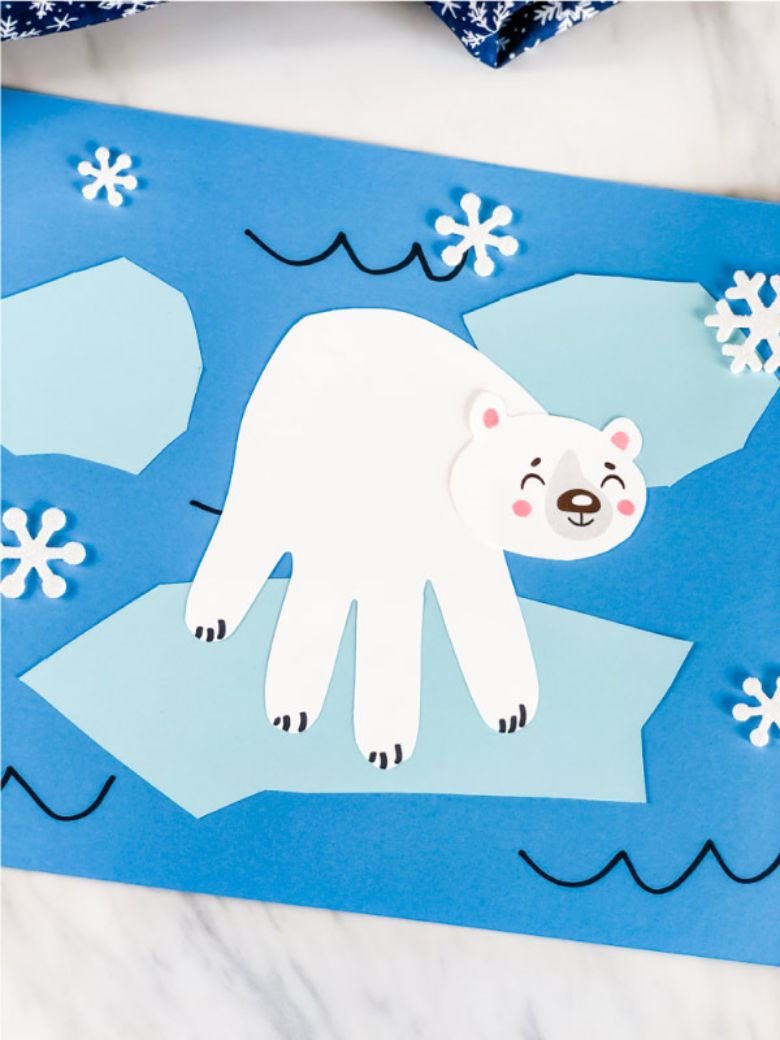 Child displaying a polar bear handprint holiday craft