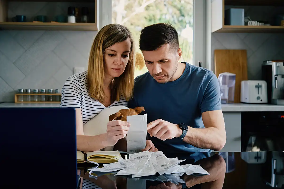 Couple checking bills and planning family budget at kitchen table