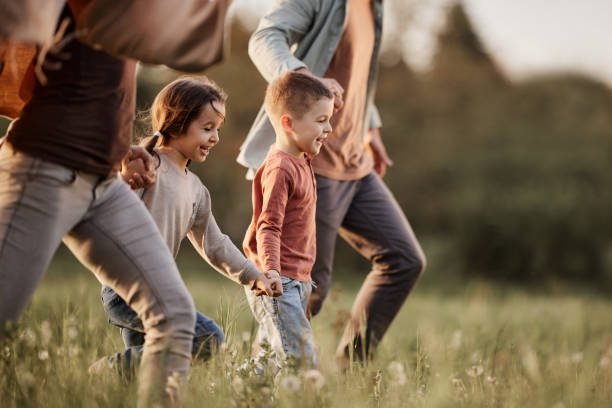 Family enjoying spring outdoors in Canada with kids running in the park
